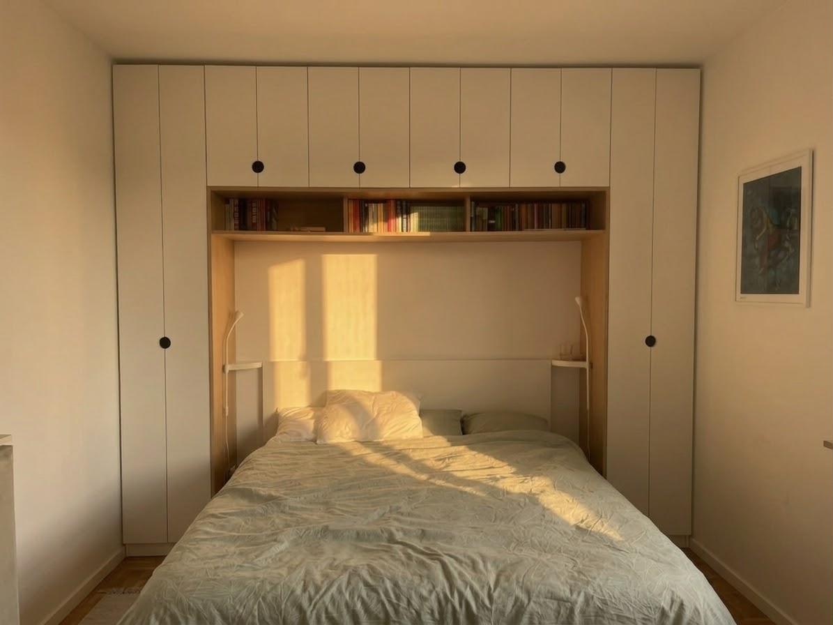The bed nook, wraparound joinery with the circular door pulls, centered, late light