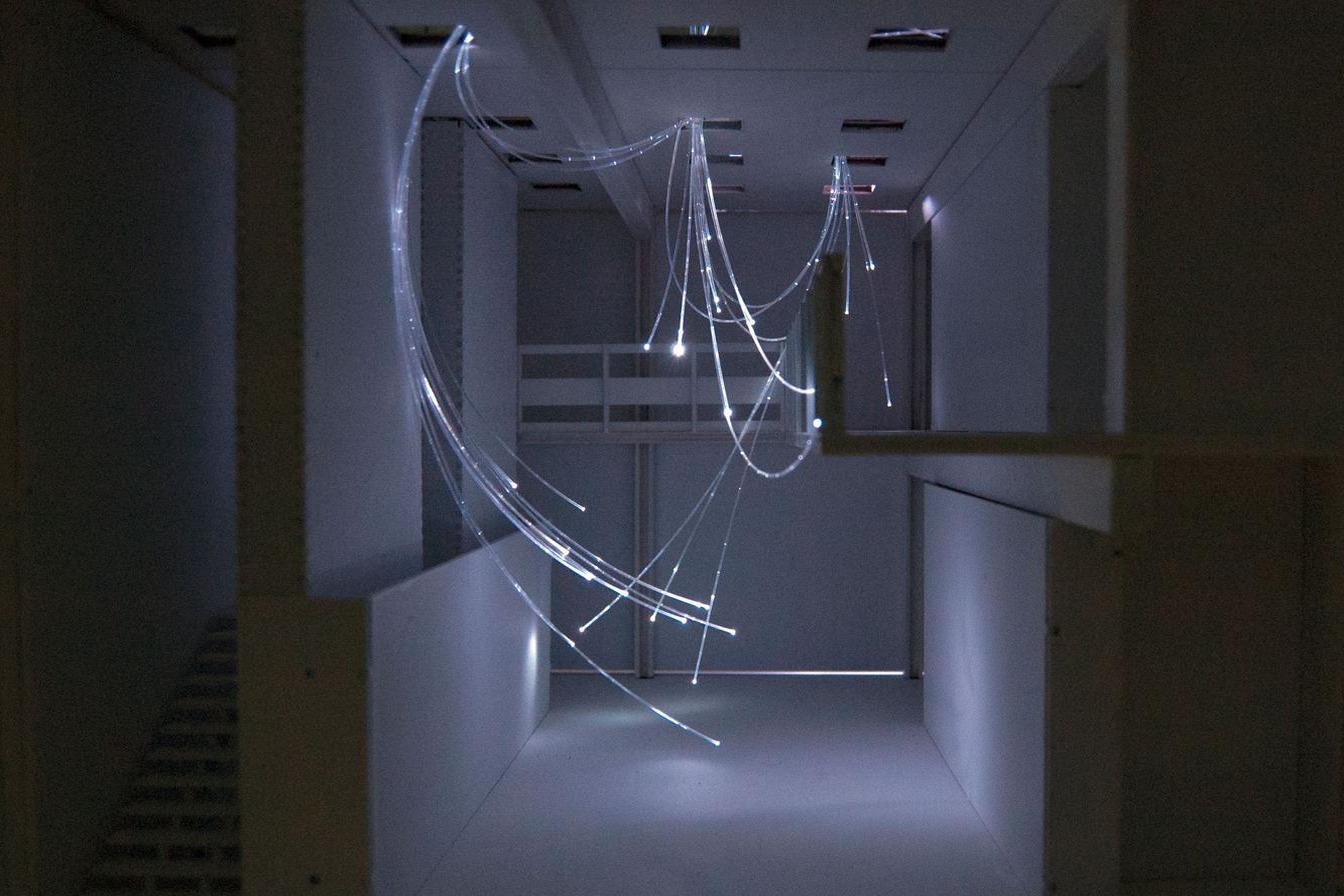 OpticTendril installation, fibre-optic strands cascading through the stairwell