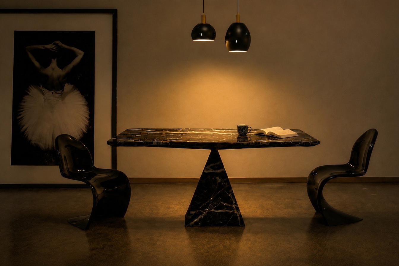 The Table at night, marble top lit by pendant lamps, an open book and coffee left on it